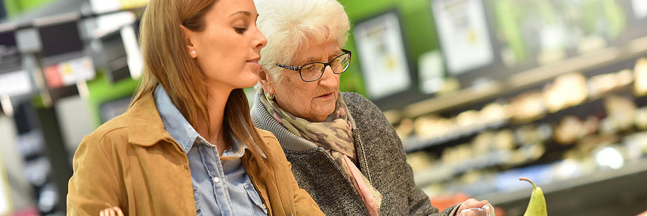 Einkaufshilfe vom DRK Junge Frau und Seniorin im Supermarkt, bei der Auswahl von Obst