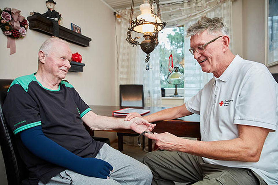 Pflege zuhause DRKler misst Puls bei älterem Herrn